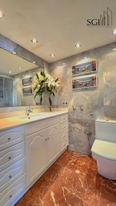 ein Badezimmer mit einem weißen Waschbecken und einer Toilette in der Unterkunft Primera línea de playa- First line Beach in Benidorm