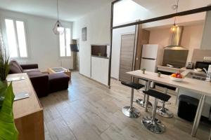 a living room with a couch and a table in a room at Atelier des rêvesVieuxPortProche PlagesLaCiotat in La Ciotat