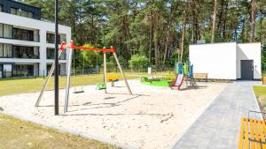 a playground in a park with a swing at Prywatne apartamenty w Sea Shell, Sun & Snow in Łukęcin