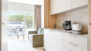 a kitchen with a couch and a living room at Prywatne apartamenty w Sea Shell, Sun & Snow in Łukęcin