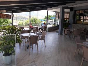 a restaurant with tables and chairs and people sitting at tables at Qiqi Hotel in Gjirokastër