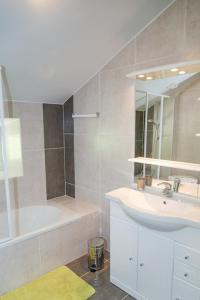 a bathroom with a sink and a tub and a mirror at Gîte du haut au cayre in Mas-dʼOrcières +12 photos
