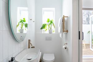 Un baño con lavabo, inodoro y espejo. en 107 Dorpstraat Boutique Hotel, en Stellenbosch 84 fotos más