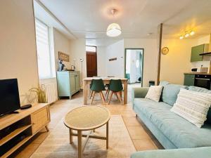 a living room with a blue couch and a table at Laon'Vert in Laon