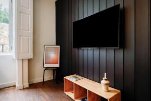 sala de estar con TV en una pared negra en Cosme Apartments by Olala Homes, en Oporto