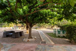 un parque con un árbol, una mesa y bancos en Stoupa Serene Nests - Spitiko Getaway, en Stoupa 27 fotos más