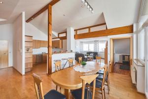 a kitchen and dining room with a wooden table and chairs at Hotel Hornstein in Nonnenhorn