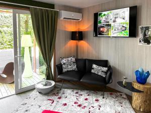 a living room with a black couch and a tv at Luxury Camp at Union Lido in Cavallino-Treporti