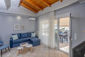 a living room with a blue couch and a table at Foteini's central apartment in Néa Péramos
