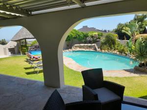 a view of a swimming pool from the patio of a house at Luxury flat with magnificent views in Plattrkloof in Cape Town