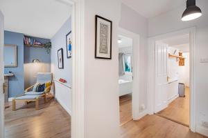 a hallway with a room with blue walls and a chair at Pass the Keys Private Garden Apartment by Tulse Hill Station in London