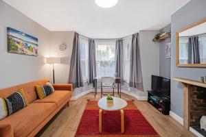 a living room with a couch and a table at Pass the Keys Private Garden Apartment by Tulse Hill Station in London
