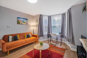 a living room with a couch and a table at Pass the Keys Private Garden Apartment by Tulse Hill Station in London