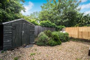 a garden with a wooden shed in a yard at Pass the Keys Private Garden Apartment by Tulse Hill Station in London