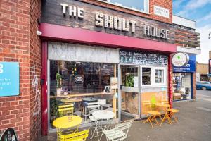 a store with tables and chairs outside of a building at Pass the Keys Private Garden Apartment by Tulse Hill Station in London