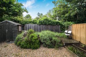 a garden with a wooden fence and two chairs at Pass the Keys Private Garden Apartment by Tulse Hill Station in London