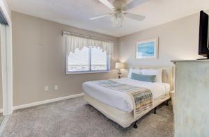 a bedroom with a bed and a ceiling fan at 1114 Boundless Awe by Atlantic Towers in Carolina Beach