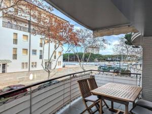 萨卡罗Apartamento En el Port dAro by Host&Joy的观景阳台的木桌和椅子
