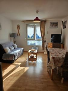 a living room with a bed and a table at résidence vallée des lacs in Le Tholy