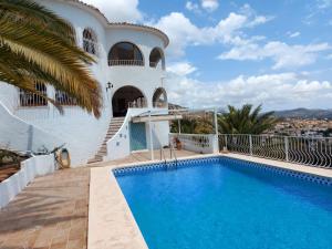 a villa with a swimming pool in front of a house at Amazing view villa in Calpe