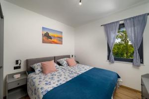 una camera da letto con un letto blu e una finestra di Villa Bepo by IstriaLux a Marčana Altre 44 foto