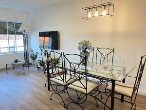 蓬塔德尔加达Modern Condo的配有玻璃桌椅的餐厅