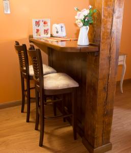 Una barra de madera con dos sillas y un jarrón de flores. en Casadelavilla, en Fuentepinilla
