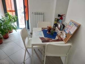 a dining room table with two white chairs and a table with at Grigio Pesca in Salerno +65 photos