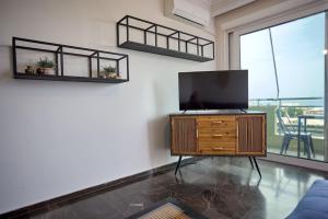 a living room with a flat screen tv on a wooden cabinet at Panoramic White Blue in Chios