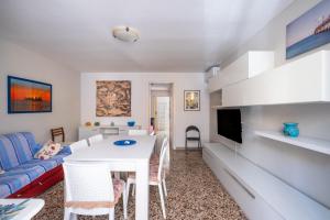 a living room with a white table and a blue couch at Gió home in Santa Maria al Bagno