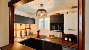 a kitchen with a counter with a sink and a microwave at Charmant T2 en coeur de ville 15min de Disney in Lagny