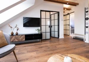 a living room with a flat screen tv on a wall at Gemütliches Loft-Retreat in Treuchtlingen