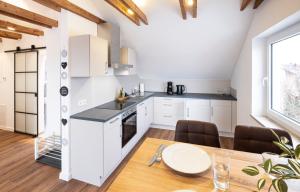 a kitchen and dining room with white cabinets and a table at Gemütliches Loft-Retreat in Treuchtlingen