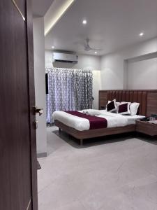 a bedroom with two beds and a television in it at Sai Ram Regency in Bhayandar