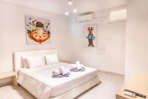 een slaapkamer met een groot wit bed in een kamer bij Limani Lux Apartments in Karpathos +17 foto's