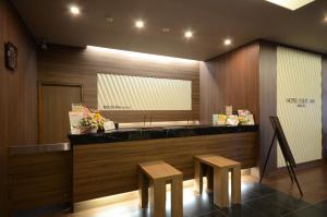 a lobby with a counter with two stools in front of it at Hotel Route Inn Annaka in Annaka