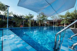 a large blue swimming pool with an umbrella at Chan Living in Semporna