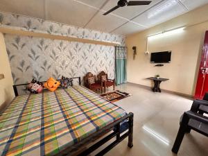 a bedroom with a bed and a tv in it at Abhigyanam Home Stay in Guwahati