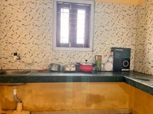 a kitchen counter with a sink and a window at Abhigyanam Home Stay in Guwahati +13 photos