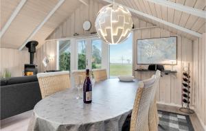a dining room with a table with a bottle of wine at Holiday Home Flejmose Sydals X Denmark in Kegnæshøj