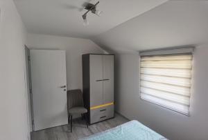a bedroom with a bed and a cabinet and a window at Apartmani Račanka in Bajina Bašta
