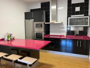 a kitchen with a red counter top and appliances at Casa La Oliva Vejer in Vejer de la Frontera