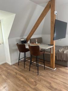 a room with a table and chairs in a attic at Room Deluxe in Meerbusch