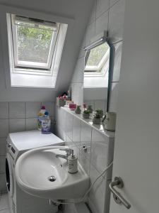 a bathroom with a sink and two windows at Room Deluxe in Meerbusch