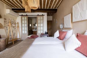 una camera da letto con un grande letto bianco con cuscini rossi di La Sanverine private room historic center Vence a Vence