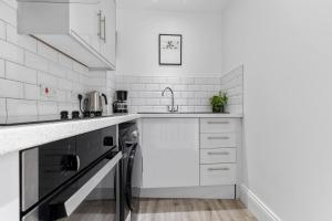a white kitchen with a sink and a dishwasher at Pass the Keys 4 35 Fossgate Cosy Central 2-Bed Home Right in the Heart of York in York