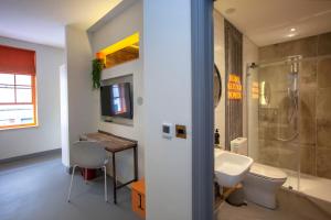 a bathroom with a sink and a toilet and a shower at Higgihaus Aparthotel, Clare Street in Bristol