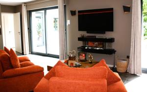 TV a/nebo společenská místnost v ubytování L'ApothéOse, gîte bien-être avec jacuzzi, sauna, hammam