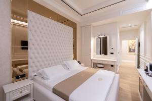 a white bedroom with a large bed and a bathroom at King & Queen Boutique Hotel in Fier +64 photos