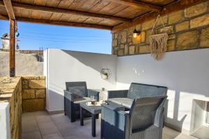 a patio with chairs and a table on a wall at Villa Chris - Malona in Malona Village